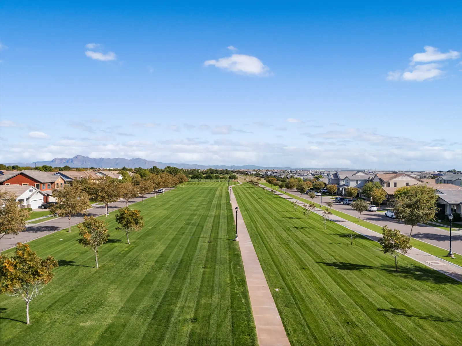 A walking path through a broad greenbelt between homes in Morrison Ranch, Gilbert