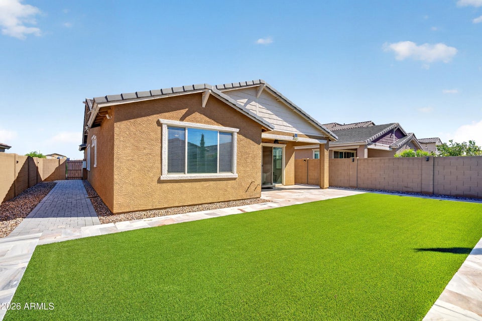 Low-maintenance backyard with artificial turf and extended pavers